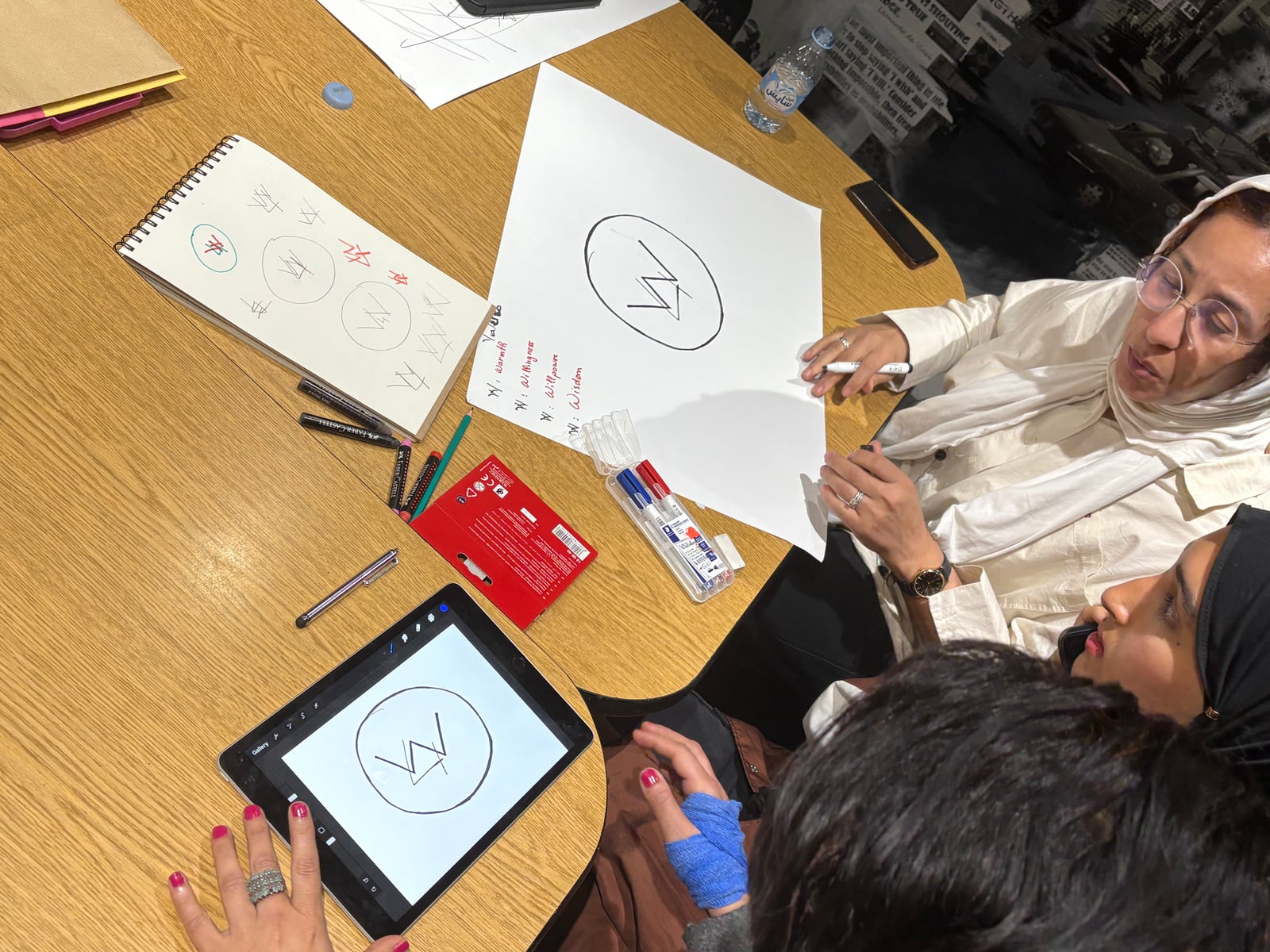Workshop participants developing a graphic idea on paper and a tablet