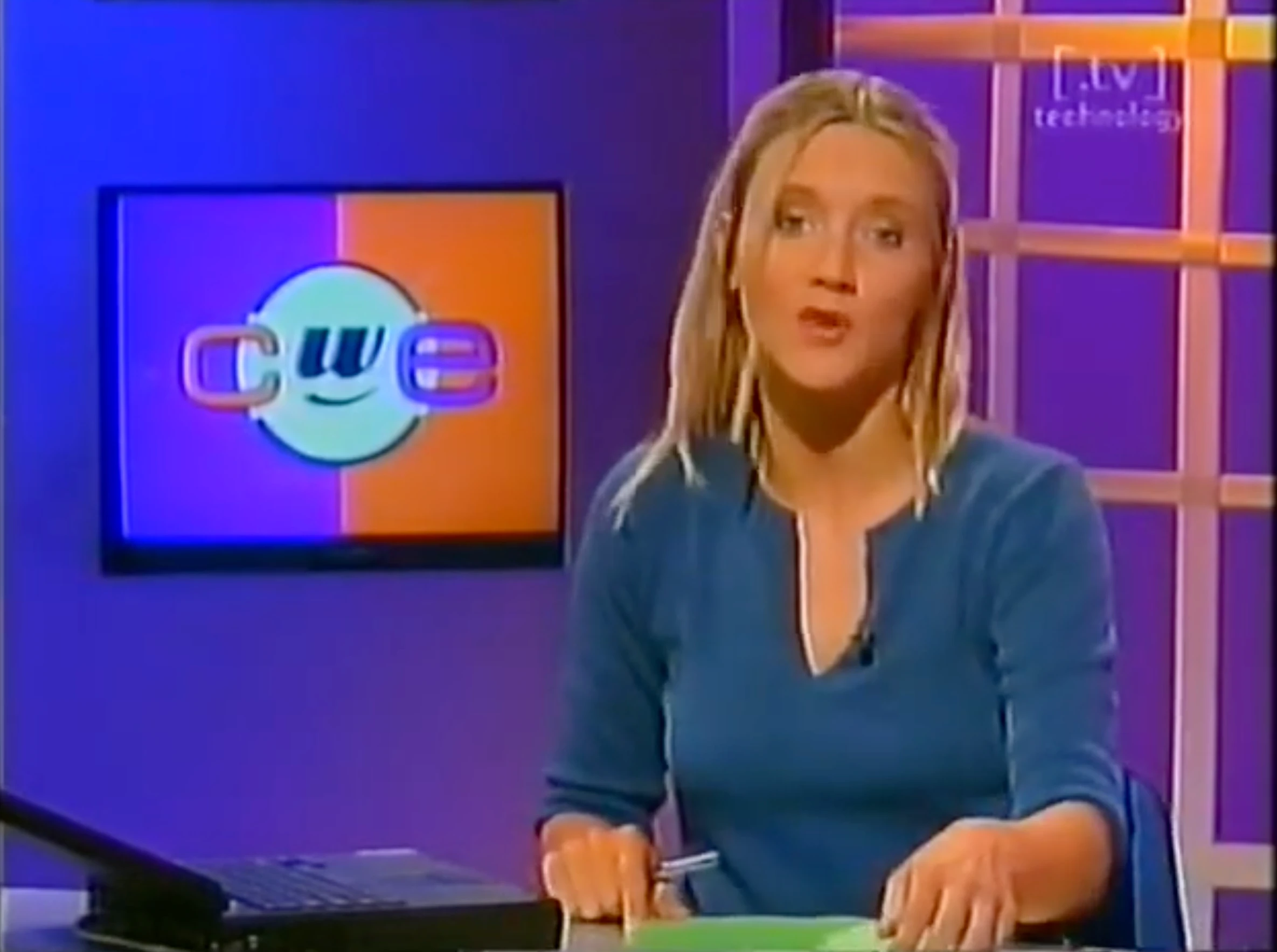 A television still from Chips with Everything showing the presenter and programme logo